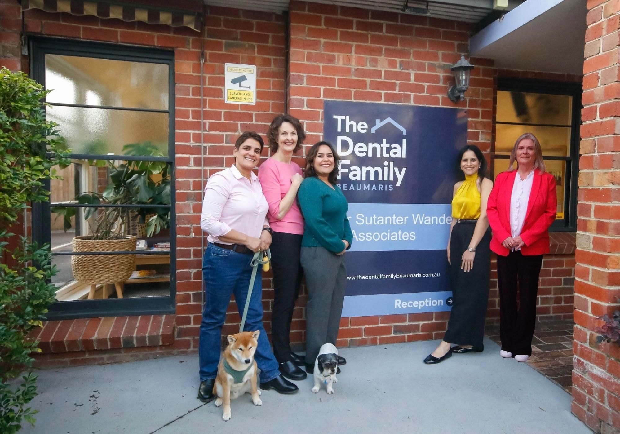 The Dental Family Beaumaris team and their two dogs outside the practice on Balcombe Road